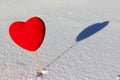 Red heart on the snow with the shadow