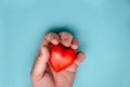 The red heart is squeezed by a man`s hand. Royalty Free Stock Photo