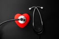 Red heart and stethoscope on Black paper. Flat lay essential items for doctor using treat and care patient in hospital Royalty Free Stock Photo