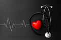 Red heart and stethoscope on Black paper. Flat lay essential items for doctor using treat and care patient in hospital Royalty Free Stock Photo