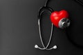 Red heart and stethoscope on Black paper. Flat lay essential items for doctor using treat and care patient in hospital Royalty Free Stock Photo