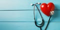 Red heart and stethoscope on blue wooden background Royalty Free Stock Photo