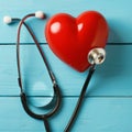 Red heart and stethoscope on blue wooden background Royalty Free Stock Photo