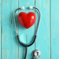 Red heart and stethoscope on blue wooden background Royalty Free Stock Photo