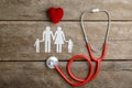 Red heart, stethoscope and paper chain family on wooden table Royalty Free Stock Photo