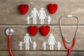 Red heart, stethoscope and paper chain family on wooden table Royalty Free Stock Photo