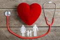 Red heart, stethoscope and paper chain family on wooden table Royalty Free Stock Photo