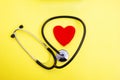 Red heart and stethoscope on yellow background, heart health care and medical technology concept, selective focus, Royalty Free Stock Photo