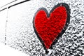 Red Heart symbol on frozen window of the car. Shape of heart drawn on snow on front window of the car. Heart snow. Christmas decor Royalty Free Stock Photo