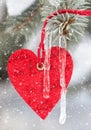 Red heart toy on fir tree with snowfall Royalty Free Stock Photo