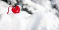 Red heart toy in snowfall on fir tree Royalty Free Stock Photo