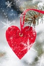 Red heart toy with snowflake on fir tree Royalty Free Stock Photo