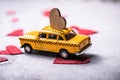 Red heart on toy yellow  taxi car on red background. Travel love concept with copy space Royalty Free Stock Photo