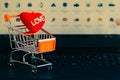 Red heart in a trolley on a laptop keyboard. Ideas about online shopping.