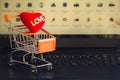 Red heart in a trolley on a laptop keyboard. Ideas about online shopping, online shopping
