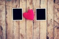 Red heart and two photo frame hanging on clothesline rope with w Royalty Free Stock Photo