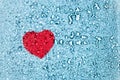 Red heart under water drops on glass on blue background with copy space Royalty Free Stock Photo