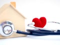 Red heart using stethoscope on the blue background for house health check. Concept of love and caring patient house by the heart. Royalty Free Stock Photo