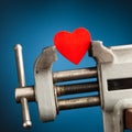 Red heart in the vice tool Royalty Free Stock Photo