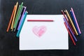 Red heart on white paper drawn by pencil on black background. Pencils around. Love Mother`s day concept. Royalty Free Stock Photo