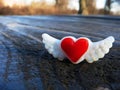 Red heart with wings magnet on picnic table.