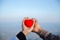 Red heart in woman and man hands, hands holding a soft heart shape, Couple love, Valentine`s Day