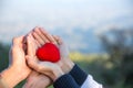 Red heart in woman and man hands, hands holding a soft heart shape, Couple love, Valentine`s Day