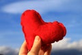 Red heart in woman's hand with blue sky in background , Valentine's day