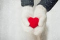 Red heart in woman`s hands wearing white woolen mittens. Valentine`s Day concept Royalty Free Stock Photo