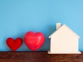 Red heart with wooden house on blue background isolated. copy space for text and content. concept of love and family Royalty Free Stock Photo
