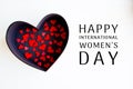 Red hearts in a black box with a heart and Happy 8 March International Women`s Day lettering