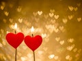 Red hearts candles on golden hearts bokeh as background Royalty Free Stock Photo