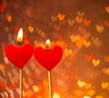 Red hearts candles on warm hearts bokeh as background Royalty Free Stock Photo