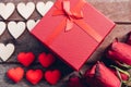 Red hearts, flower roses and gift box on wooden background Royalty Free Stock Photo