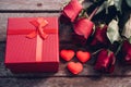 Red hearts, flower roses and gift box on wooden background Royalty Free Stock Photo