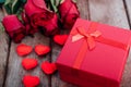 Red hearts, flower roses and gift box on wooden background Royalty Free Stock Photo