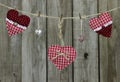 Red hearts and heart-shaped locks hanging on clothesline by distressed wood fence Royalty Free Stock Photo