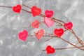 Red hearts with an inscription Love hang on branches on a gray concrete background. Love tree. The concept of Valentine's Day. A Royalty Free Stock Photo