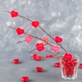 Red hearts with an inscription Love hang on branches on a gray concrete background. Love tree. The concept of Valentine's Day. A Royalty Free Stock Photo