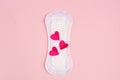 Red hearts and daily, menstrual woman pad for hygiene or blood period on pink background