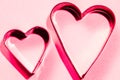 Red hearts from metal moulds on pink background