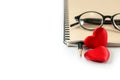 Red hearts, notebook, pencil, and eyeglasses, empty space for text, Valentines day concept Royalty Free Stock Photo