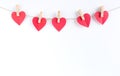 Red hearts paper on sack rope with clothespins on white background. Royalty Free Stock Photo