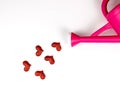 Red hearts pouring out from pink watering can on white background0 Valentine`s day concept