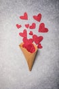 Red hearts pouring in waffle horn. Valentines love, date concept with copy space, flat lay