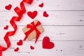 Red hearts, ribbon and gift on white wooden background. Top view, free space for text. valentine`s day, love Royalty Free Stock Photo