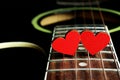 Red hearts on the strings of a guitar. Hearts are a symbol of love. Valentine`s Day