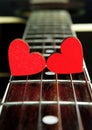 Red hearts on the strings of a guitar. Hearts are a symbol of love. Valentine`s Day