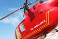 Red helicopter of air ambulance on blue sky background. Detail of the helicopter blades. Cornwall, UK