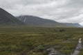 Red helicopter supply Hikers at Mountain Lodge Salka STF hut. Lapland mountain ladscape on summer cloudy day Royalty Free Stock Photo